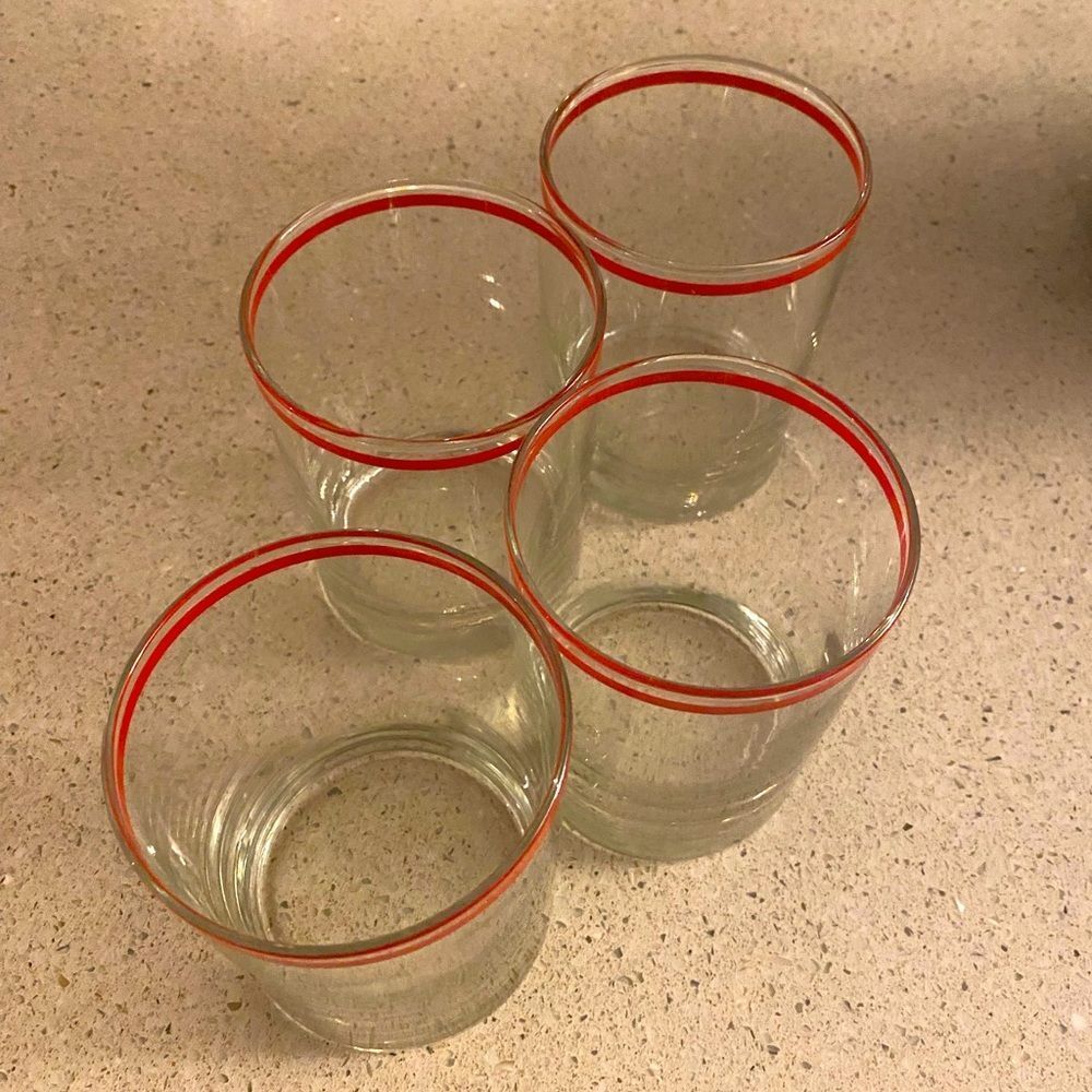 Four matching whiskey glasses with red detail